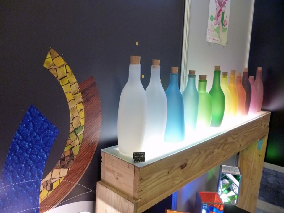 Alignement de bouteilles soufflées rétroéclairées, du blanc au vert.