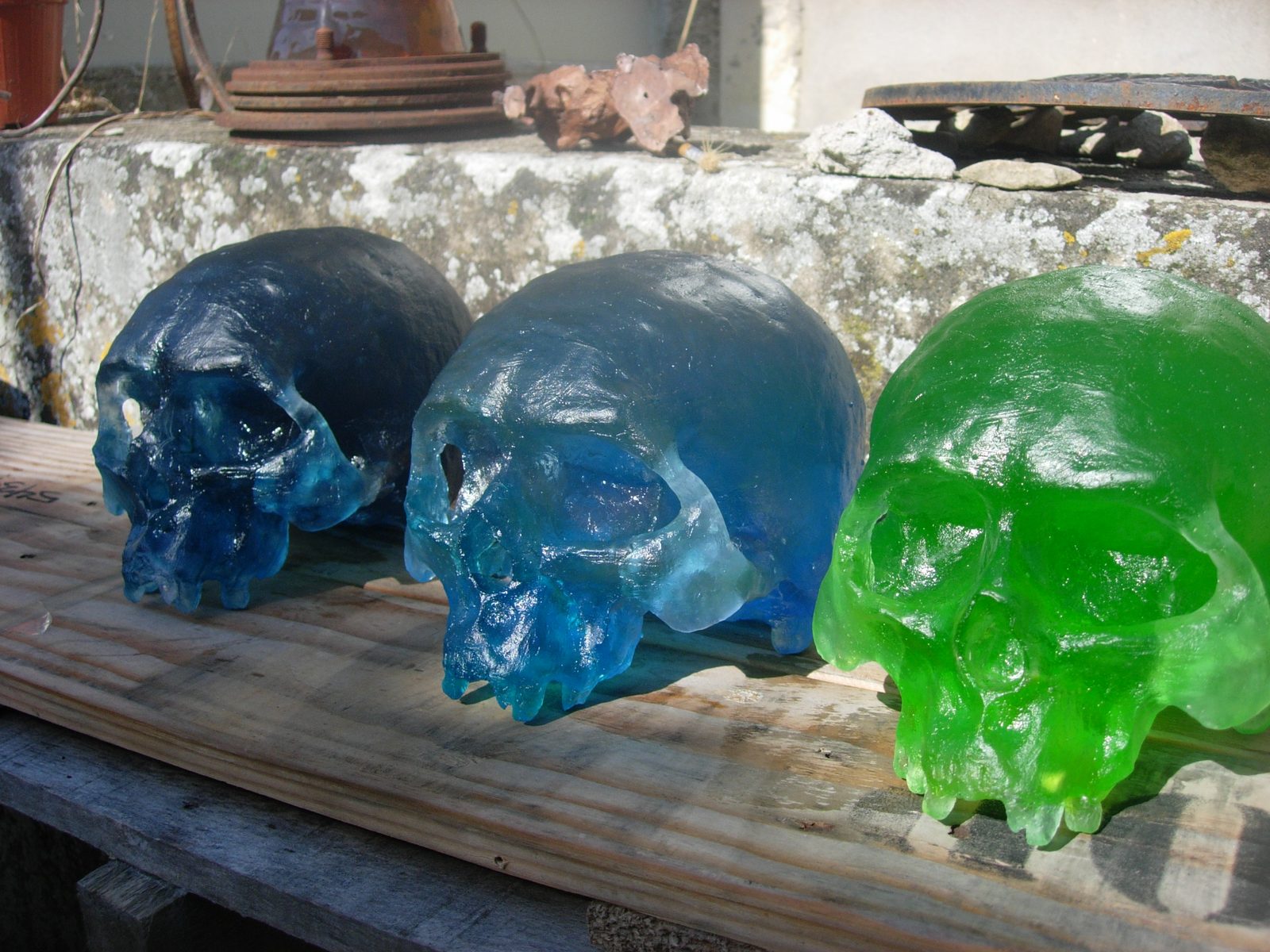 Trois crânes en pâte de verre, bleu, turquoise et vert.