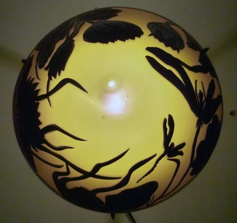Lampe en verre sablé à décor de feuillages noirs sur fond ambré.